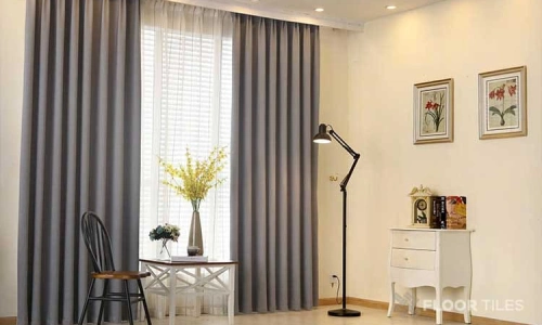 A bright room featuring elegant grey blackout curtains, perfect for homes in District One.