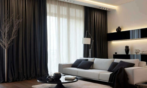 Contemporary living room with a white sofa, black decor, and dramatic, dark blackout curtain dubai covering a large window