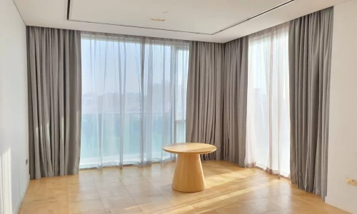 The outer layer consists of thick grey blackout curtains drawn back to reveal a sheer white layer.