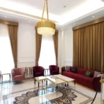 A luxurious modern sitting area featuring gold two-tone living room blackout curtains with matching valances