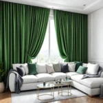 Large emerald green velvet living room blackout curtains framing a window behind a white L-shaped couch with decorative throw pillows.