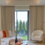 Modern living room featuring floor-to-ceiling wave style living room blackout curtains in a neutral beige