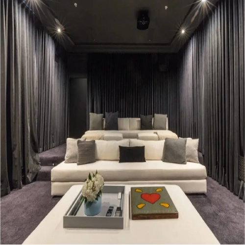 A modern, high-end cinema space featuring media room blackout curtains in a charcoal gray velvet.