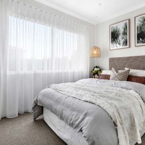 American Style Standard Sheer curtains in a bright, modern bedroom. The floor-to-ceiling white sheers are hung on a wide window