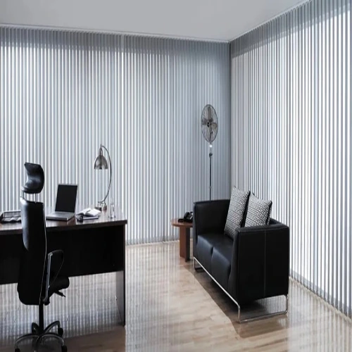 A modern home office featuring floor-to-ceiling sheer blackout curtains in light gray.