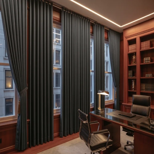 A sophisticated home office featuring floor-to-ceiling charcoal grey blackout curtains draped over large windows