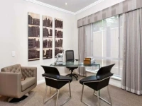 Large window covered by floor-to-ceiling home office blackout curtains in a light grey striped pattern.