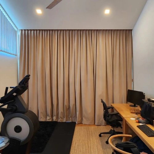 Soundproof home office curtain in a neutral beige fabric spans the entire back wall of a room