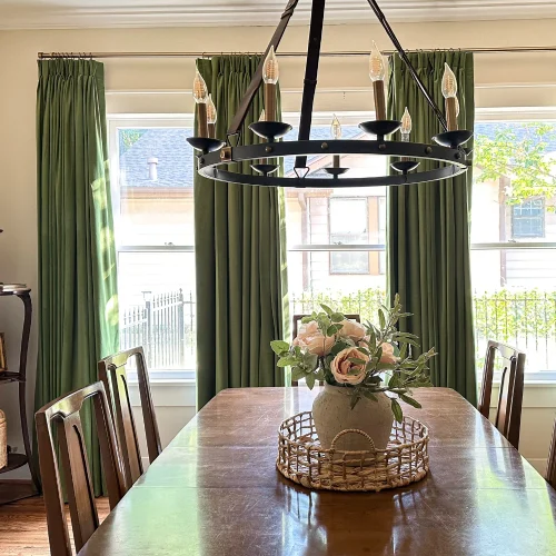 With large windows framed by olive green dining area blackout curtains.