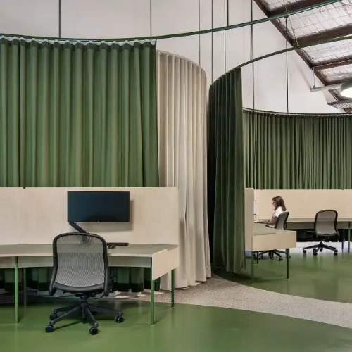 green and cream privacy curtains that create semi-private circular workstations.