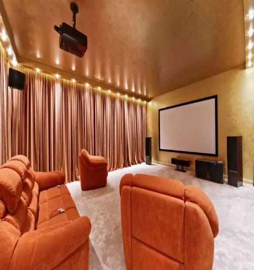 A luxurious dedicated cinema room featuring floor-to-ceiling home theater blackout curtains in a rich bronze velvet