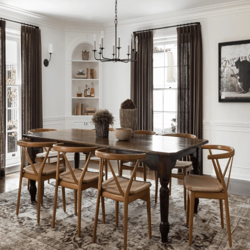 A rustic wooden dining table paired with light wood wishbone chairs, set against large windows framed by floor-to-ceiling dining area blackout curtains in a deep espresso brown.