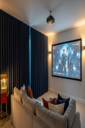Modern media room featuring navy blue home theater blackout curtains with deep pleats