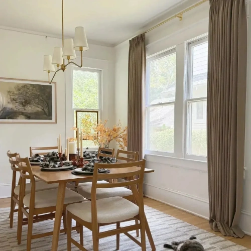 dining area blackout curtains hanging from a brass rod to provide light control and privacy.