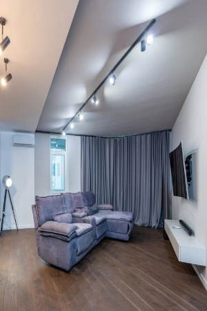 gray home theater blackout curtains mounted on a curved ceiling track to provide full window coverage.