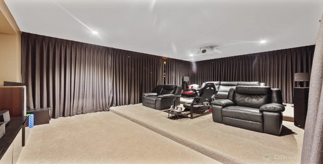 home theater blackout curtains in a dark mocha fabric that fully covers the walls to eliminate external light and glare.